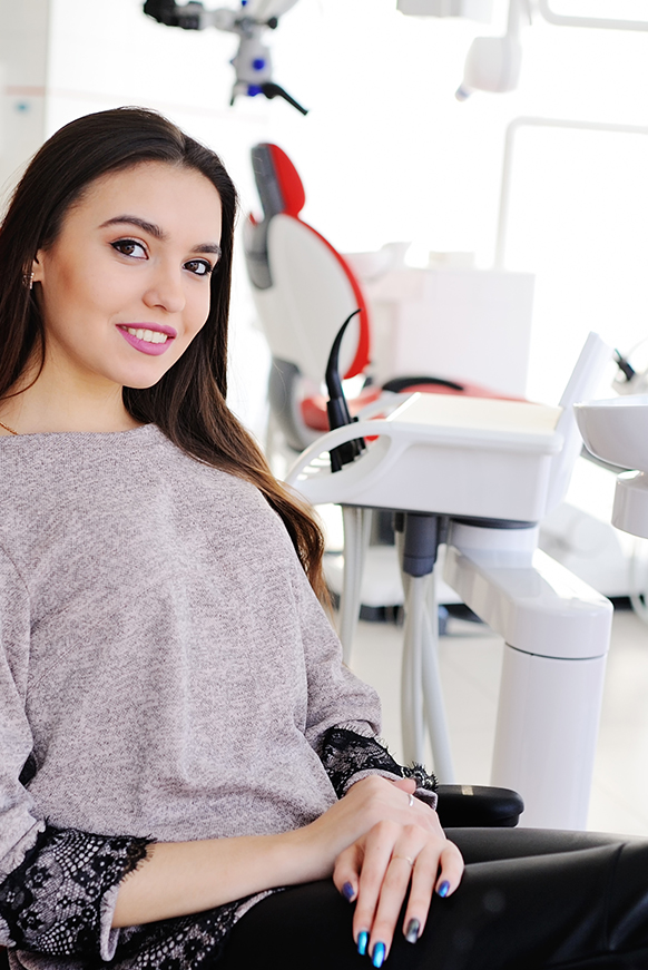 Attractive woman in dental chair smiling
