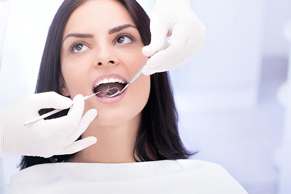 Miami Florida cosmetic dentistry - young woman in dental chair being seen by dentist. 