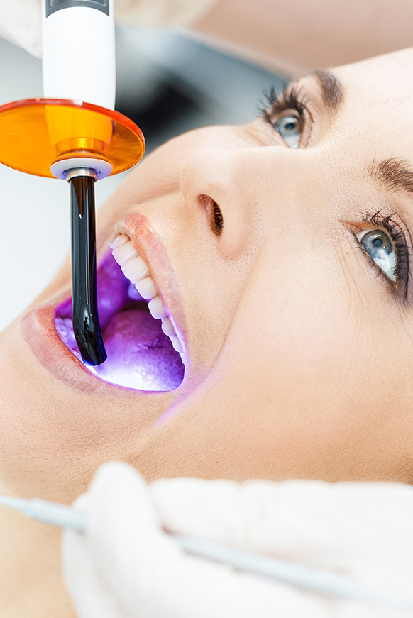 Woman in dental chair recieving cosmetic dental procedure
